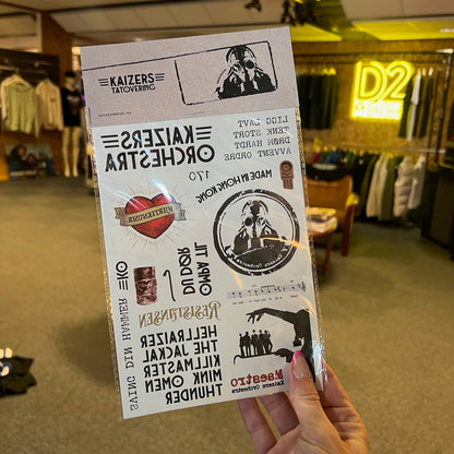 Person holding a set of temporary tattoos in Kaizers Orchestra design in showroom
